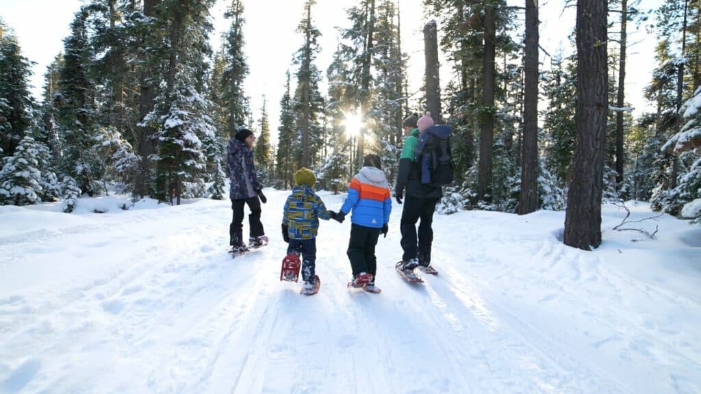 a family snowshoeing in the woods